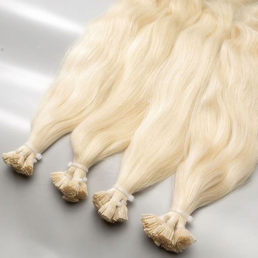 A set of lightest blonde human hair extensions with a keratin bond, displayed on a white surface.
