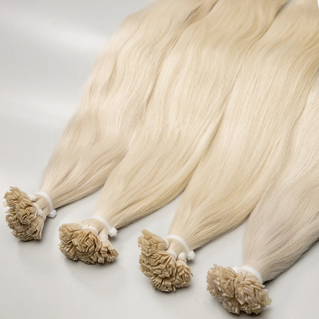A set of platinum blonde K-tip hair extensions tied in bunches with a beige keratin bonding agent.
