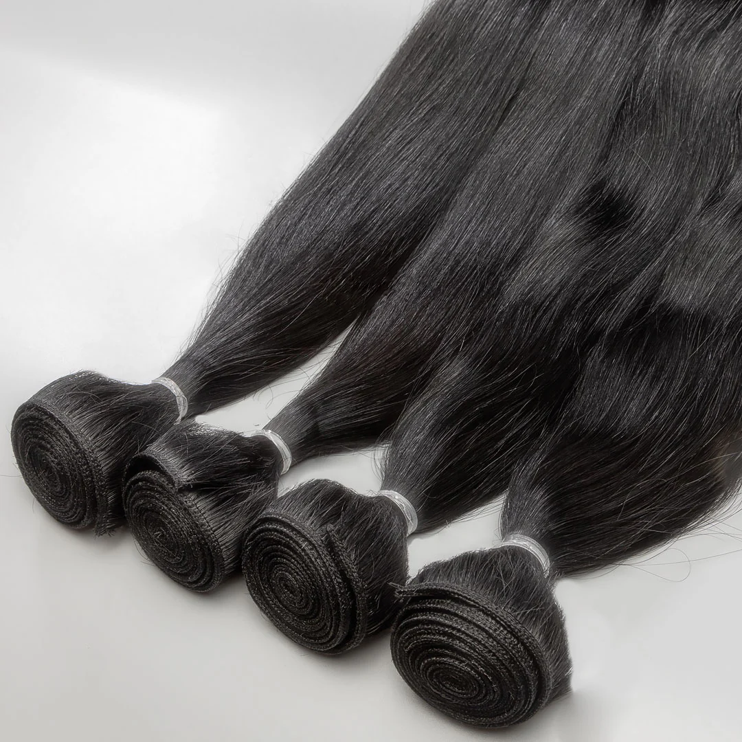 A collection of black weft hair extensions tied in bunches with white ribbons.