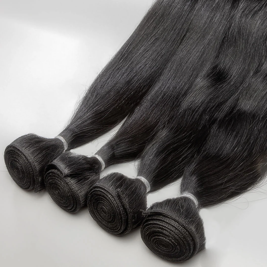 A collection of black weft hair extensions tied in bunches with white ribbons.