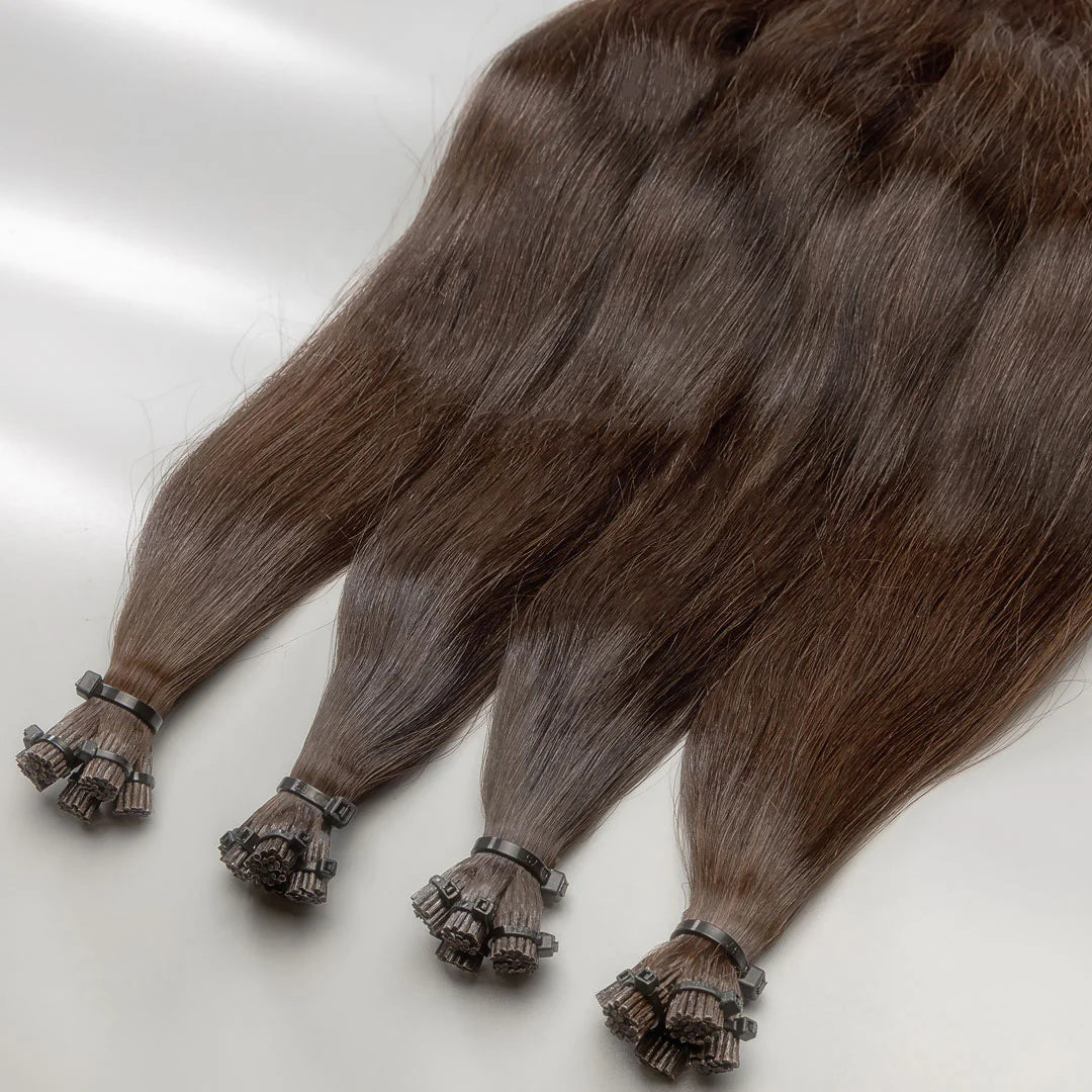 A photo of medium brown I-tip hair extensions laid out on a surface.