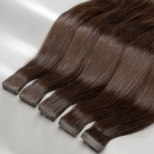 A set of medium brown tape-in hair extensions laid out on a surface.