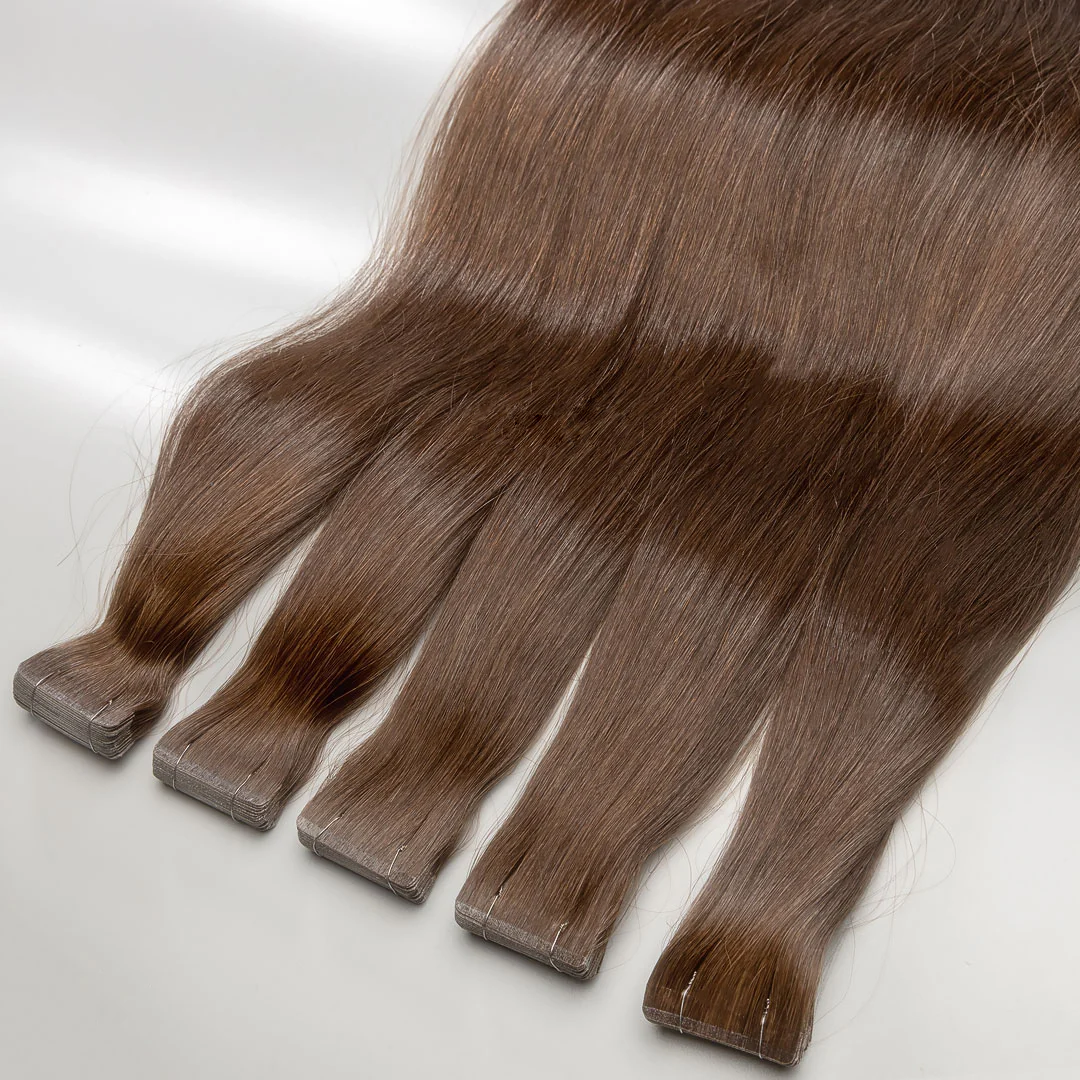 A set of light brown tape-in hair extensions displayed on a surface.