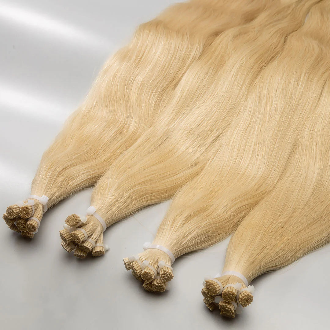 A set of blonde-colored hair extensions with an I-tip style, displayed on a white background.