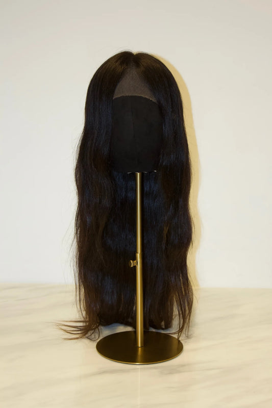 A black premium 100% human hair wig displayed on a stand, with the hairline featuring a pre-plucked hairline with baby hairs.